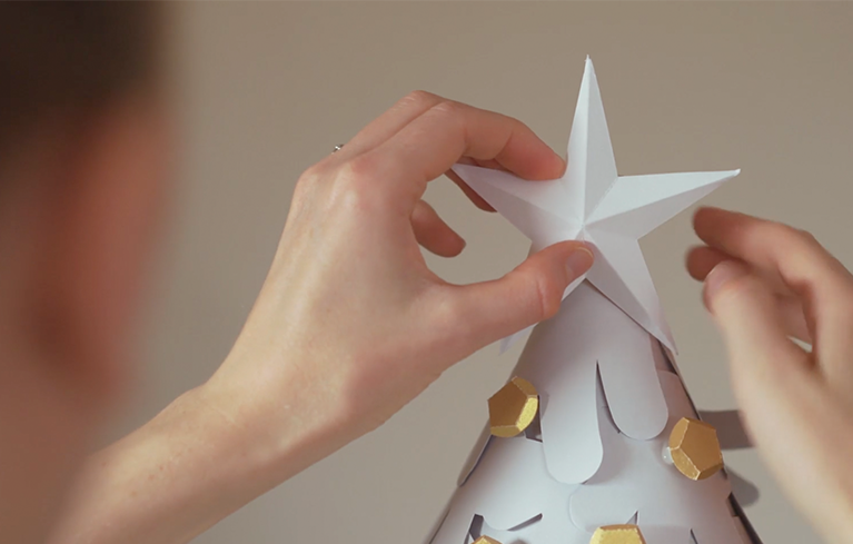 Assemblage d'une étoile en papier plié dans le cadre de l'oeuvre créée pour l'affiche du marché de Noël